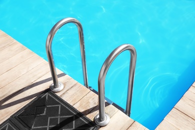 Photo of Modern swimming pool with step ladder outdoors