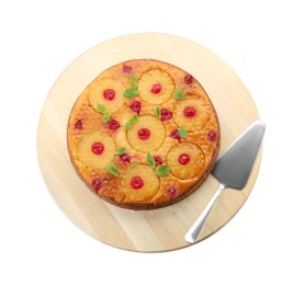 Photo of Board with tasty pineapple cake and spatula on white background, top view