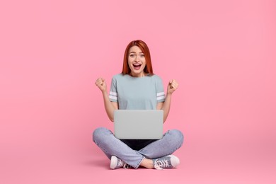 Photo of Happy young woman with laptop on pink background