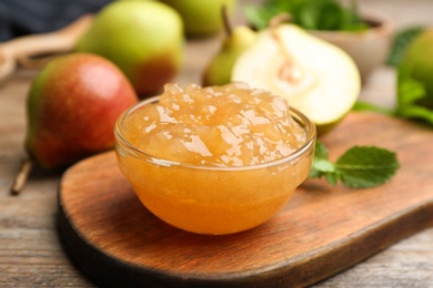 Photo of Delicious pear jam and fresh fruits on wooden table, closeup