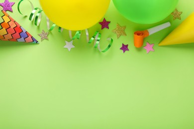 Different accessories for birthday party on green background, flat lay. Space for text