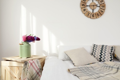 Photo of Beautiful hyacinths in metal can on wooden crate indoors, space for text. Spring flowers