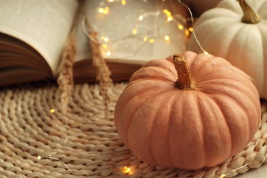 Photo of Pumpkins and book on wicker mat indoors