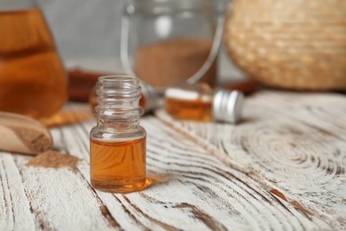 Photo of Closeup of bottle with cinnamon oil on wooden table