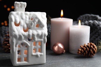 Photo of Composition with candles in house shaped holders on grey table. Christmas decoration