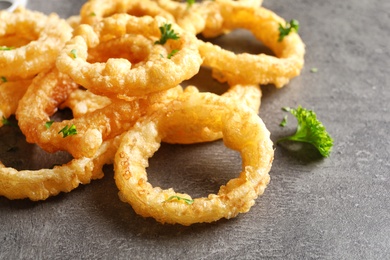 Photo of Homemade crunchy fried onion rings on color table, closeup