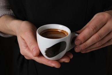 Photo of Woman holding cup of fresh aromatic espresso, closeup