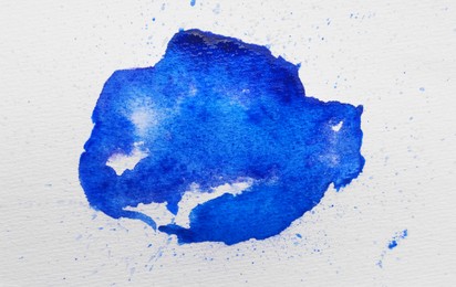 Photo of Blot of blue ink on white background, top view