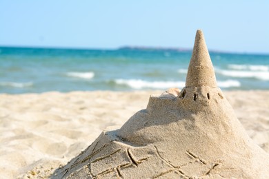 Photo of Beach with sand castle near sea on sunny day. Space for text