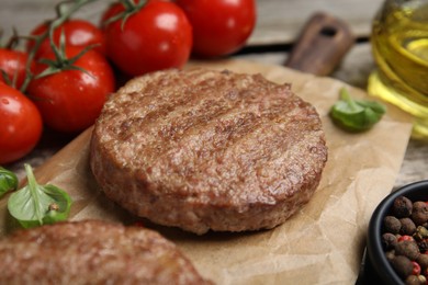 Photo of Tasty grilled hamburger patties with basil served on table, closeup