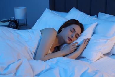Photo of Beautiful young woman sleeping in bed at night