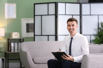 Photo of Young male psychologist in office