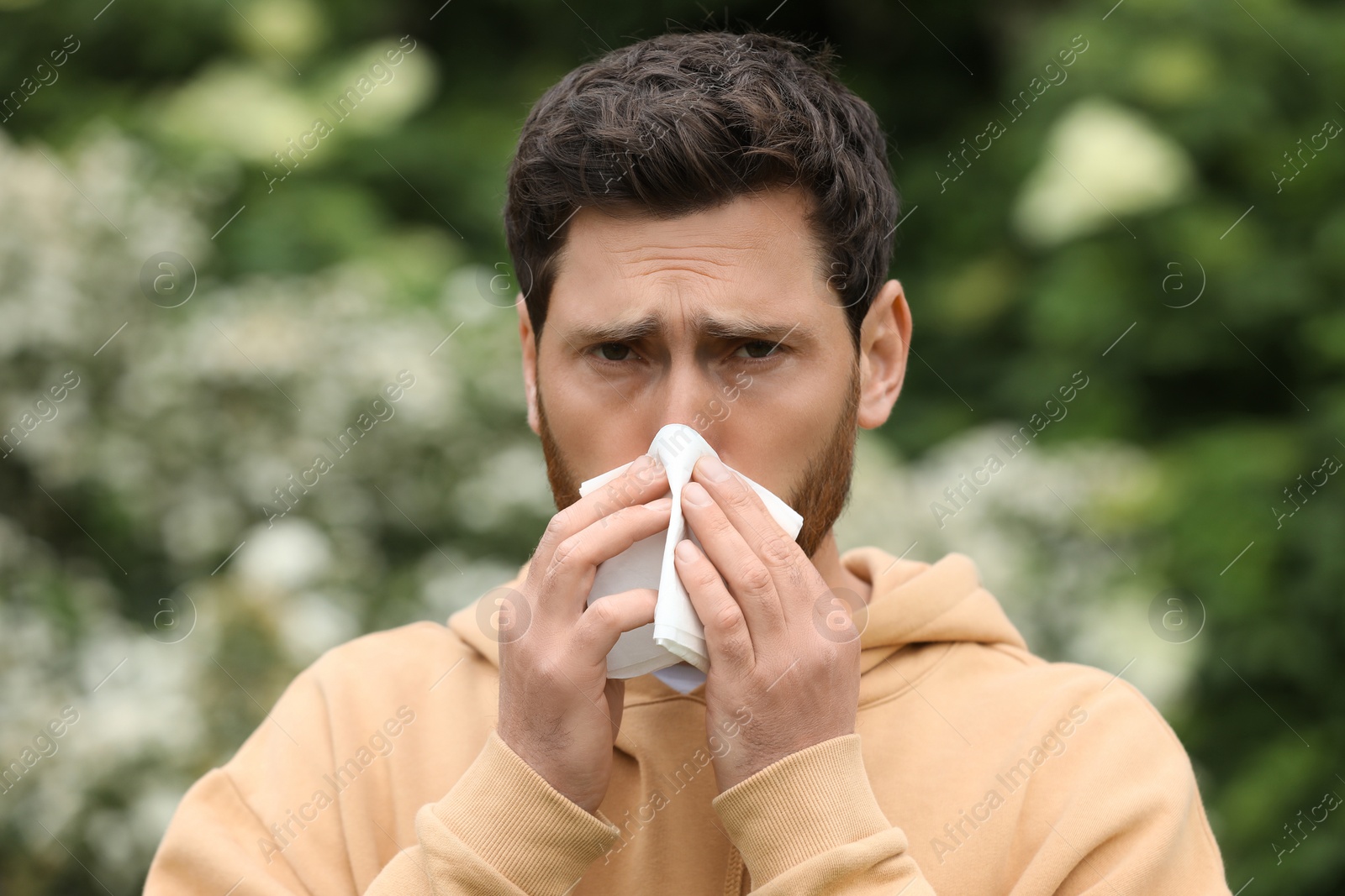 Man suffering from seasonal spring allergy outdoors Photo of Man suffering from seasonal spring allergy outdoors