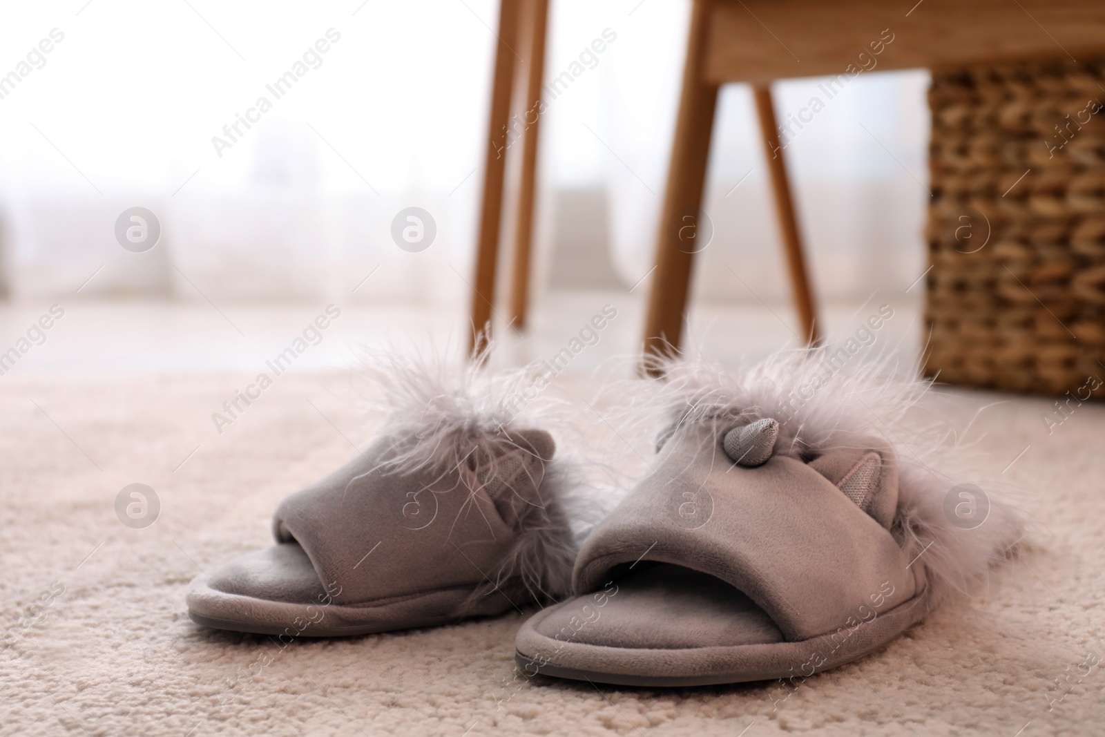 Photo of Pair of light grey slippers on floor in room