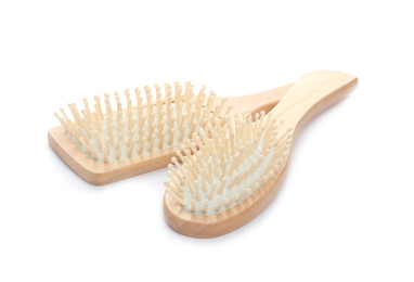 Photo of New wooden hair brushes on white background