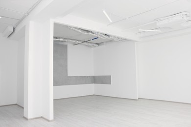 Photo of Empty room with white ceiling and ventilation system during repair
